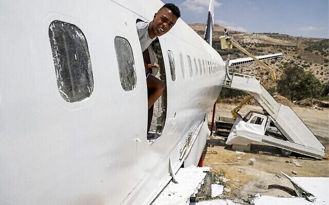 Un jeune jette un coup d'œil par une ouverture dans le fuselage d'un Boeing 707 transformé en restaurant par les frères jumeaux palestiniens Atallah et Khamis al-Sairafi, près de la ville de Naplouse en Cisjordanie, le 5 juillet 2021. (Crédit : JAAFAR ASHTIYEH / AFP)
