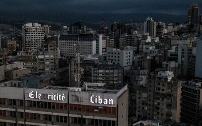 Vue aérienne de Beyrouth, la capitale du Liban, dans l'obscurité pendant une panne de courant, avec au premier plan le siège de la compagnie nationale Électricité du Liban, le 3 avril 2021. (Crédit : Dylan COLLINS / AFP)