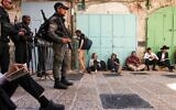 Des hommes juifs à l'extérieur de l'enceinte de la mosquée Al-Aqsa à Jérusalem, alors que les forces de sécurité israéliennes montent la garde lors du jeûne annuel de Tisha BeAv (9 du mois d’Av), le 18 juillet 2021. (Crédit : AHMAD GHARABLI / AFP)