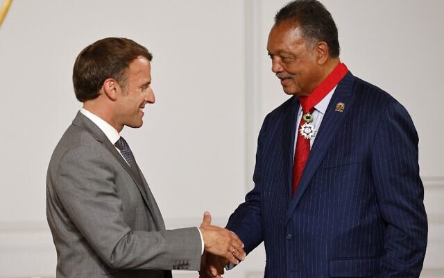 Le président français Emmanuel Macron serre la main du révérend Jesse Jackson (à droite), militant américain des droits civiques, après lui avoir décerné la Légion d'honneur à l'Elysée, à Paris, le 19 juillet 2021. (Crédit : Ludovic MARIN / POOL / AFP)
