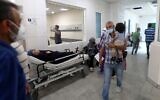 Un patient sur un lit dans un couloir de l'hôpital universitaire Rafic Hariri à Beyrouth, la capitale du Liban, le 23 juillet 2021. (Crédit : STR/AFP)