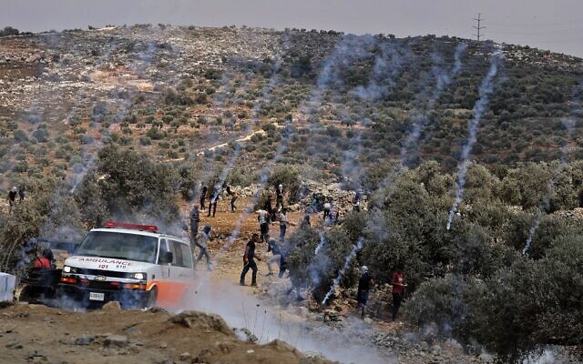 Des grenades lacrymogènes tirées par l'armée israélienne atterrissent au milieu de manifestants palestiniens lors de confrontations dans la ville de Beita, près de la ville de Naplouse en Cisjordanie, le 23 juillet 2021, après une manifestation contre l'avant-poste israélien d'Evyatar. (Crédit : JAAFAR ASHTIYEH/AFP)
