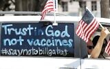 Des manifestants avec un panneau « Faites confiance à Dieu, pas aux vaccins » devant l'hôtel de ville de Los Angeles, le 22 avril 2020. (Crédit : Mario Tama/Getty Images/AFP)