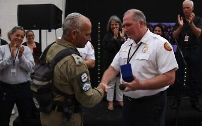 SURFSIDE, FLORIDA - JULY 10: Le chef des sapeurs-pompiers du comté de Miami Dade, Alan Cominsky, remet une médaille à Golan Vach, commandant de l'unité de secours de l'armée israélienne envoyée en Floride suite à la catastrophe de Surfside, lors d'une cérémonie en date du 10 juillet 2021. (Crédit :  Anna Moneymaker / GETTY IMAGES NORTH AMERICA / Getty Images via AFP)