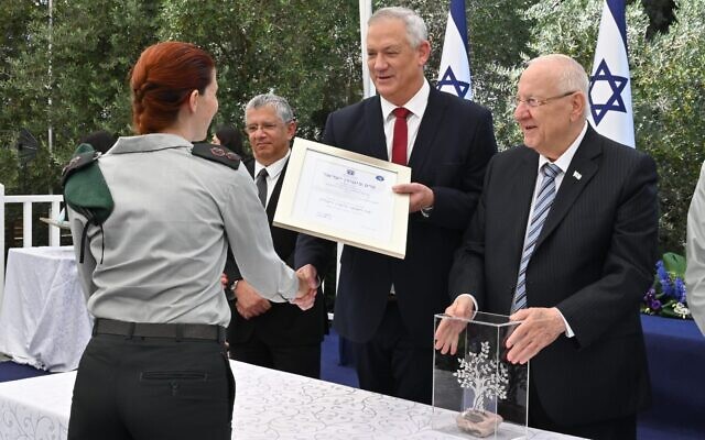 Le ministre de la Défense Benny Gantz remet le prix de la sécurité Golomb à une responsable non-identifiée des services de renseignement militaire israéliens aux côtés du président   Reuven Rivlin, à droite, et du directeur-général du ministère de la Défense,   Amir Eshel, à la résidence du président de Jérusalem, le 5 juillet 2021. (Crédit : Ariel Hermoni/Ministère de la Défense)