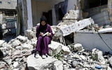 Une femme devant la maison de sa famille dans le camp de réfugiés de Rafah, dans le sud de la bande de Gaza, le 15 juin 2021. (Crédit : Adel Hana/AP)