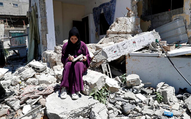 Une femme devant la maison de sa famille dans le camp de réfugiés de Rafah, dans le sud de la bande de Gaza, le 15 juin 2021. (Crédit : Adel Hana/AP)