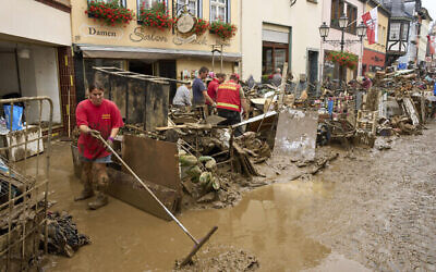 Photo d'illustration: Des habitants et des commerçants tentent de dégager la boue de leurs maisons et de déplacer les meubles inutilisables à l'extérieur à Ahrweiler, dans l'ouest de l'Allemagne, samedi 17 juillet 2021. De fortes pluies ont provoqué des coulées de boue et des inondations dans l'ouest de l'Allemagne. (Crédit : Thomas Frey/dpa via AP)