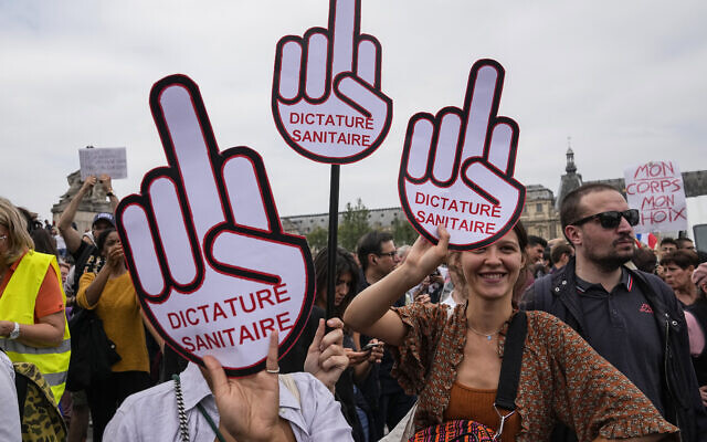 Des manifestants anti-vaccins tiennent une pancarte lors d'un rassemblement à Paris, le samedi 17 juillet 2021. (Crédit :  AP/Michel Euler)