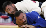 Vazha Margvelashvili de Géorgie, en haut, et Baruch Shmailov d'Israël s'affrontent pendant leur match de judo masculin de -66kg en quart de finale des Jeux olympiques d'été de 2020, le 25 juillet 2021, à Tokyo, au Japon. (Crédit : AP Photo/Vincent Thian)