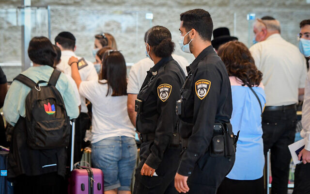Des policiers font respecter le règlement COVID-19 à l'aéroport international Ben Gurion, le 19 juillet 2021. (Crédit : AvshalomSassoni/Flash90) 