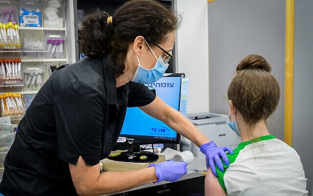 Un adolescent israélien reçoit un vaccin COVID-19 dans une clinique Maccabi à Tel Aviv, le 22 juin2021 (Crédit : Avshalom Sassoni/Flash90) 
