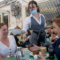 Des clients assis au Café Kadosh, à Jérusalem, en mai 2020. Ce restaurant est l'un des centaines d'établissements en Israël qui ont opté pour la certification casher en dehors des auspices du Grand Rabbinat israélien. (Crédit : Yonatan Sindel/Flash90) 
