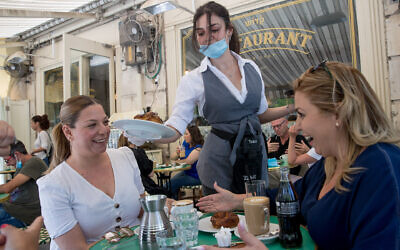 Des clients assis au Café Kadosh à Jérusalem, en mai 2020. Ce restaurant est l'un des centaines d'établissements en Israël qui ont opté pour la certification casher en dehors des auspices du Grand Rabbinat israélien. (Crédit : Yonatan Sindel/Flash90) 