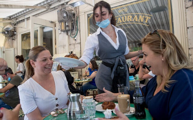 Des clients assis au Café Kadosh, à Jérusalem, en mai 2020. Ce restaurant est l'un des centaines d'établissements en Israël qui ont opté pour la certification casher en dehors des auspices du Grand Rabbinat israélien. (Crédit : Yonatan Sindel/Flash90) 