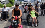 Des activistes handicapés bloquent l'autoroute Ayalon à Tel Aviv le 25 juillet 2021. (Crédit : Tomer Neuberg/Flash90)