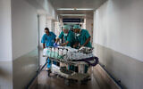 Illustration : Des médecins et des infirmières traitent un patient à l'hôpital Wolfson à Holon. (Crédit : Hadas Parush/Flash90)