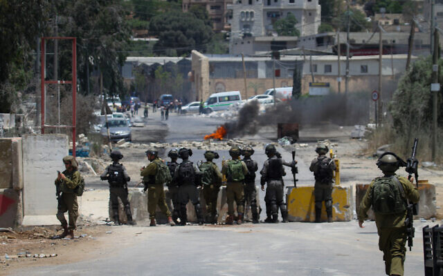 Des manifestants palestiniens jettent des pierres aux soldats israéliens pendant des affrontements lors d'une manifestation à Beita, en Cisjordanie, le 8 juin 2021. (Crédit : Nasser Ishtayeh/Flash90 Des manifestants palestiniens jettent des pierres aux soldats israéliens pendant des affrontements lors d'une manifestation à Beita, en Cisjordanie, le 8 juin 2021. (Crédit : Nasser Ishtayeh/Flash90