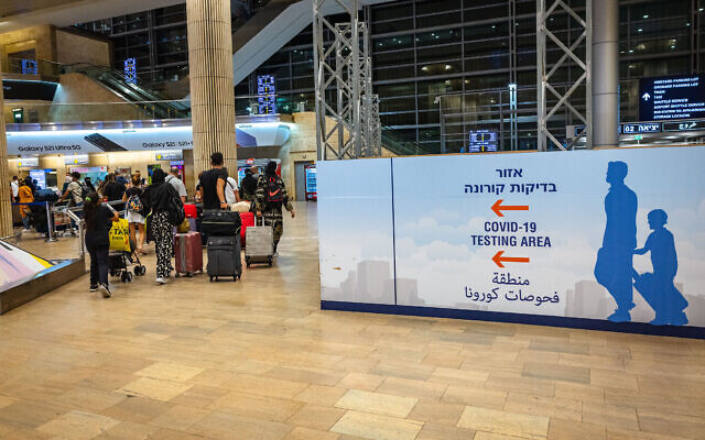 Des voyageurs arrivés à l'aéroport international Ben-Gurion, en Israël, se dirigent vers la zone de dépistage du coronavirus, le 1er juillet 2021. (Crédit : Nati Shohat/FLASH90)