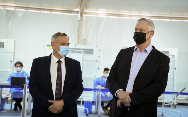 Le ministre de la Défense Benny Gantz, à droite, et le ministre de la Santé Nitzan Horowitz visitent une tente de dépistage du Covid-19 pour les passagers entrants à l'aéroport international Ben Gurion près de Tel Aviv, le 12 juillet 2021. (Crédit : Flash90) Le ministre de la Défense Benny Gantz, à droite, et le ministre de la Santé Nitzan Horowitz visitent une tente de dépistage du Covid-19 pour les passagers entrants à l'aéroport international Ben Gurion près de Tel Aviv, le 12 juillet 2021. (Crédit : Flash90)