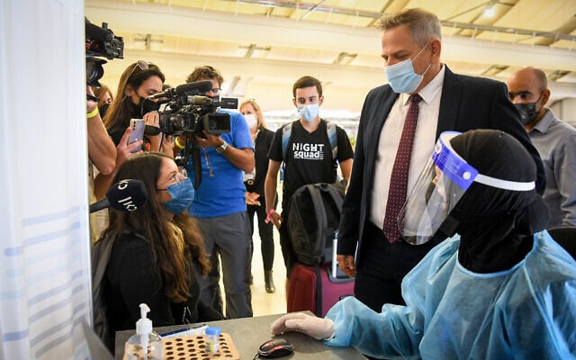 Le ministre de la Santé Nitzan Horowitz supervise des techniciens médicaux qui testent les passagers pour le COVID-19 à l'aéroport international Ben Gurion près de Tel Aviv, le 12 juillet 2021. (Crédit : Flash90) Le ministre de la Santé Nitzan Horowitz supervise des techniciens médicaux qui testent les passagers pour le COVID-19 à l'aéroport international Ben Gurion près de Tel Aviv, le 12 juillet 2021. (Crédit : Flash90)