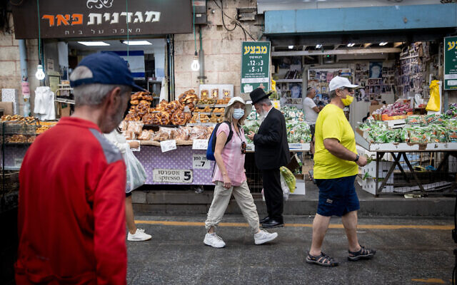 Des Israéliens portent le masque sur le marché Mahane Yehuda à Jérusalem, le 15 juin 2021. (Crédit : Yonatan Sindel/Flash90) Des Israéliens portent le masque sur le marché Mahane Yehuda à Jérusalem, le 15 juin 2021. (Crédit : Yonatan Sindel/Flash90)