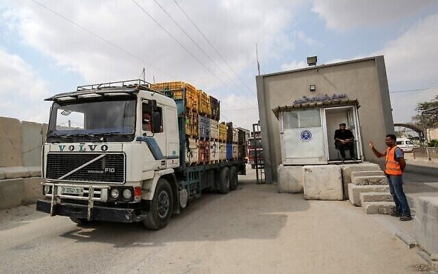 Un policier palestinien fait signe à un camion alors qu'il entre par le passage de Kerem Shalom dans la bande de Gaza, le 1erseptembre 2020, après un accord avec Israël sous médiation qatarie. (Crédit : SAIDKHATIB / AFP) Un policier palestinien fait signe à un camion alors qu'il entre par le passage de Kerem Shalom dans la bande de Gaza, le 1erseptembre 2020, après un accord avec Israël sous médiation qatarie. (Crédit : SAIDKHATIB / AFP)
