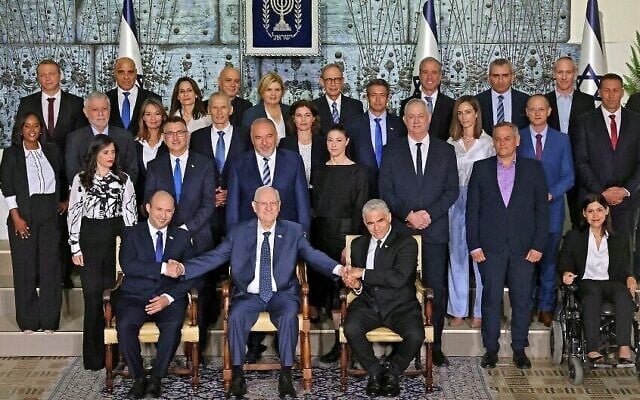 Les ministres du gouvernement israélien nouvellement assermenté posent pour la traditionnelle photo de groupe à la résidence du président à Jérusalem, le 14 juin 2021. (Crédit : Emmanuel Dunand / AFP)