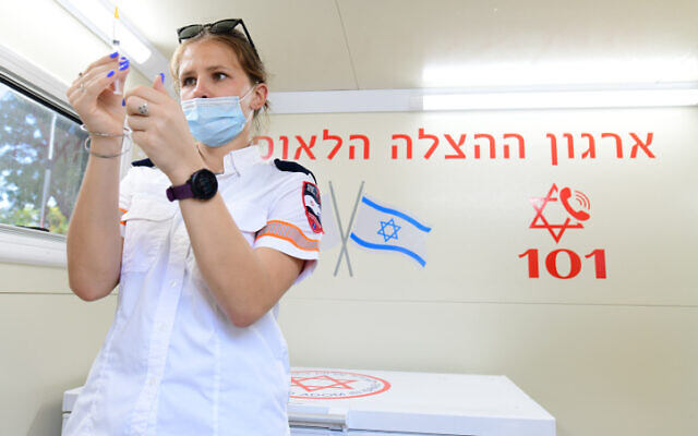 Un agent de santé prépare une vaccination contre leCOVID-19 dans un centre de vaccination de la municipalité de Tel Aviv et du Magen David Adom, à Tel Aviv, le 4 juillet 2021. (Crédit : Tomer Neuberg/Flash90)