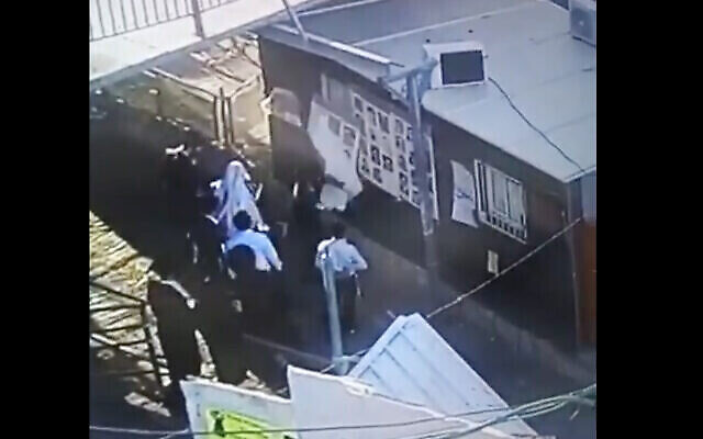 Une capture d'écran de la caméra de sécurité montre des suspects en train de vandaliser les affiches des victimes de la catastrophe du Mont Meron (Crédit : capture d'écran : Twitter)