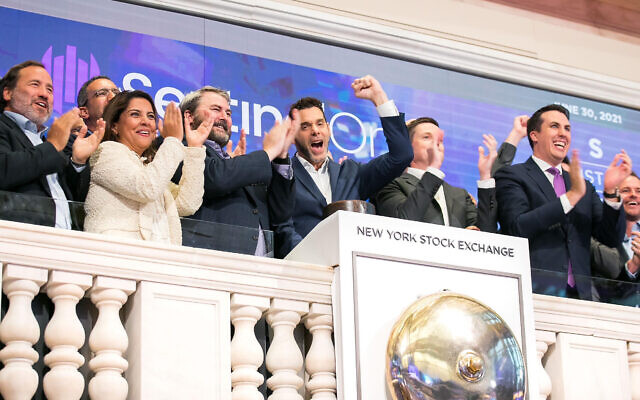 SentinelOne sonne la cloche de clôture à la Bourse de New York, le 30 juin 2021, pour célébrer son introduction en bourse. Pour l'occasion, Tomer Weingarten, cofondateur et PDG de SentinelOne, au centre avec le bras levé, est accompagné par John Tuttle, vice-président et directeur commercial de la Bourse de New York, deuxième à partir de la droite. (Crédit : NYSE)