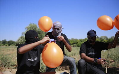 Des partisans du groupe terroriste palestinien Jihad islamique préparent des engins incendiaires portés par des ballons pour les lancer vers Israël, à l'est de la ville de Gaza, le 15 juin 2021. (Crédit : Atia Mohammed/Flash90)