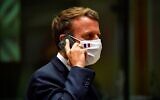 Le président français Emmanuel Macron au téléphone pendant une table ronde lors d'un sommet de l'UE à Bruxelles, le 20 juillet 2020. (Crédit : John Thys, Pool Photo via AP)
