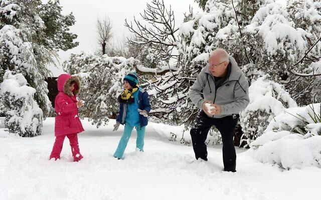 Le président Reuven Rivlin joue avec ses petits-enfants après une chute de neige à Jérusalem, le 20 février 2015. (Crédit : Haim Zach / GPO)