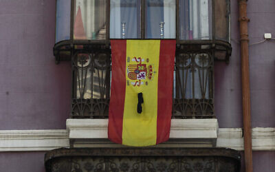Illustration : Un drapeau espagnol sur un rebord de fenêtre avec un ruban noir à Madrid, le 12 avril 2020. (Crédit: AP Photo/Bernat Armangue)