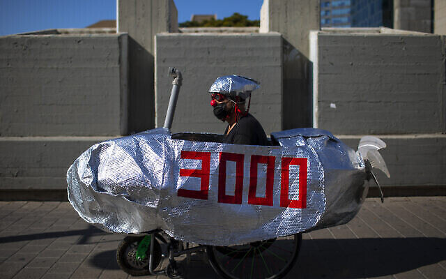 Un homme monte dans un faux sous-marin lors d'une manifestation contre le Premier ministre Benjamin Netanyahu à Tel Aviv, en Israël, mercredi 14 octobre 2020. (Crédit: AP/Oded Balilty)