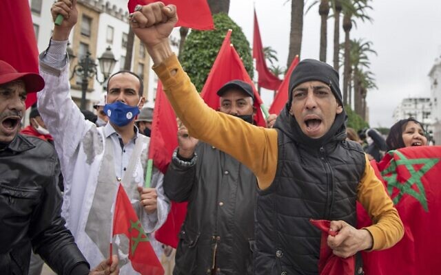 Les Marocains se réjouissent devant le parlement de Rabat après l'adoption par les États-Unis d'une nouvelle carte officielle du Maroc incluant les territoires disputés du Sahara occidental, le 13 décembre 2020. (Crédit : Fadel Senna/AFP) Les Marocains se réjouissent devant le parlement de Rabat après l'adoption par les États-Unis d'une nouvelle carte officielle du Maroc incluant les territoires disputés du Sahara occidental, le 13 décembre 2020. (Crédit : Fadel Senna/AFP)