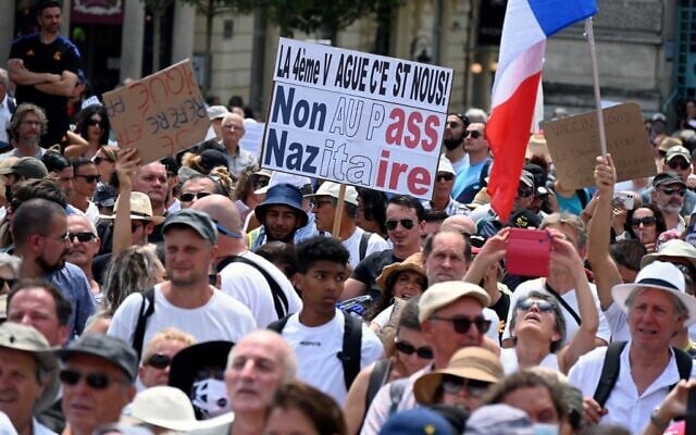 Un manifestant tient une pancarte indiquant "non au pass nazitaire" lors d'une manifestation contre la vaccination obligatoire contre la COVID-19 pour certains travailleurs et l'utilisation obligatoire du pass sanitaire réclamée par le gouvernement français, à Montpellier, le 31 juillet 2021. (Crédit :
Pascal GUYOT / AFP) Un manifestant tient une pancarte indiquant "non au pass nazitaire" lors d'une manifestation contre la vaccination obligatoire contre la COVID-19 pour certains travailleurs et l'utilisation obligatoire du pass sanitaire réclamée par le gouvernement français, à Montpellier, le 31 juillet 2021. (Crédit :
Pascal GUYOT / AFP)