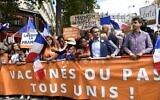 Florian Philippot, chef du parti nationaliste français "Les Patriotes", marche derrière une banderole lors d'une manifestation de protestation contre la législation française rendant obligatoire un laissez-passer sanitaire Covid-19 pour se rendre dans un café, monter à bord d'un avion ou voyager sur un train interurbain, à Paris le 31 juillet 2021. (Crédit : Bertrand GUAY / AFP)