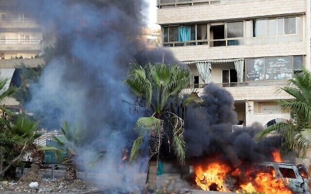 Des flammes embrasent un véhicule suite à des affrontements dans la zone de Khalde, au sud de la capitale libanaise, le 1er août 2021. (Crédit : ANWAR AMRO / AFP)