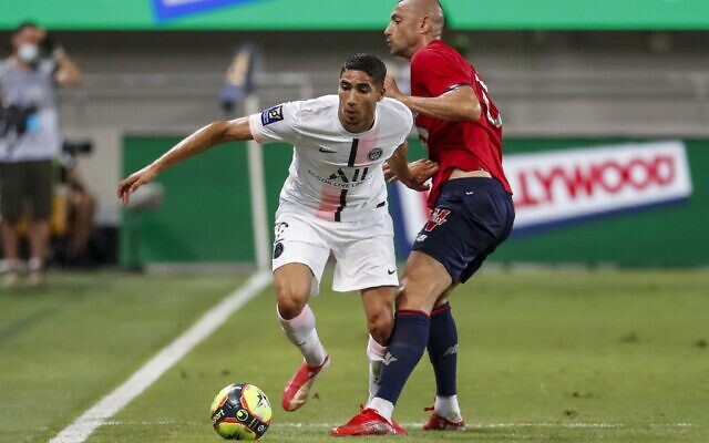 Achraf Hakimi, joueur marocain du Paris Saint-Germain, avec l'attaquant turc Burak Yilmaz de Lille lors du Trophée des Champions au stade Bloomfield à Tel Aviv, le 1er août 2021. (Crédit : EMMANUEL DUNAND / AFP)