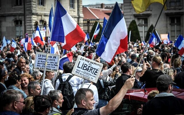 Des manifestants anti-pass sanitaire, près de l'École militaire à Paris, le 7 août 2021. (Crédit : STEPHANE DE SAKUTIN / AFP) Des manifestants anti-pass sanitaire, près de l'École militaire à Paris, le 7 août 2021. (Crédit : STEPHANE DE SAKUTIN / AFP)