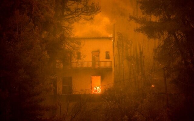 Une maison en feu alors que l'incendie d'une forêt se rapproche du village de Pefki sur l'île d'Eubée, la deuxième île la plus grande de Grèce, un feu qui serait lié au changement climatique, le 8 août 2021. Illustration (Crédit : ANGELOS TZORTZINIS / AFP) Une maison en feu alors que l'incendie d'une forêt se rapproche du village de Pefki sur l'île d'Eubée, la deuxième île la plus grande de Grèce, un feu qui serait lié au changement climatique, le 8 août 2021. Illustration (Crédit : ANGELOS TZORTZINIS / AFP)