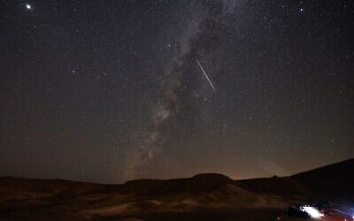La Voie lactée traversée par une météorite au-dessus du désert du Neguev, près de la ville israélienne de Mitzpe Ramon, le 13 août 2021. (Crédit : Menahem KAHANA / AFP)