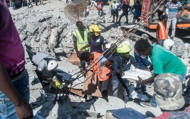 Des Haïtiens recherchent des survivants parmi les décombres dans le quartier de Dexia 6, aux Cayes, à Haïti, le 15 août 2021, après qu'un séisme de magnitude 7,2 a frappé la péninsule sud-ouest du pays. (Crédit : Réginald LOUISSAINT JR / AFP) Des Haïtiens recherchent des survivants parmi les décombres dans le quartier de Dexia 6, aux Cayes, à Haïti, le 15 août 2021, après qu'un séisme de magnitude 7,2 a frappé la péninsule sud-ouest du pays. (Crédit : Réginald LOUISSAINT JR / AFP)