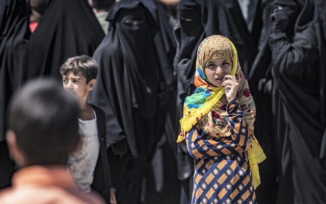 Des personnes faisant la queue pour recevoir des colis d'aide humanitaire dans le camp d'al-Hol géré par les Kurdes, dans le gouvernorat de Hasakeh, au nord-est de la Syrie, le 18 août 2021. (Crédit : Delil Souleiman/AFP)