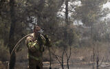 Un pompier israélien combat des feux de forêt pour le deuxième jour d’affilé près de Shoresh, à la périphérie de Jérusalem, le 16 août 2021 (Crédit : AP Photo/Maya Alleruzzo)