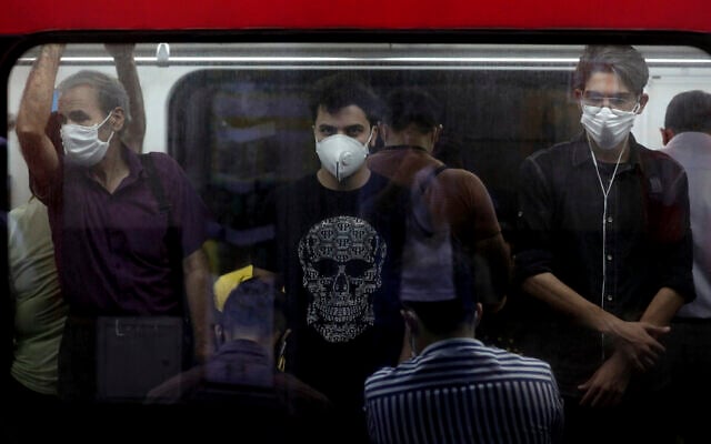 Photo d'illustration : Des Iraniens portent le masque dans le cadre de la lutte contre le coronavirus à l'intérieur d'un train à Téhéran, en Iran, le 8 juillet 2020. (Crédit : AP Photo/Ebrahim Noroozi)