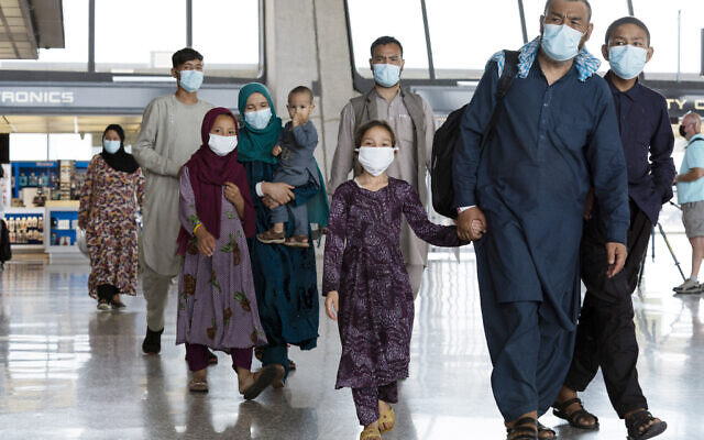Des familles évacuées de Kaboul, en Afghanistan, traversent le terminal avant de rejoindre un bus à leur arrivée à l'aéroport international Washington Dulles de Chantilly, en Virginie, le 23 août 2021. (Crédit : AP Photo/Jose Luis Magana)