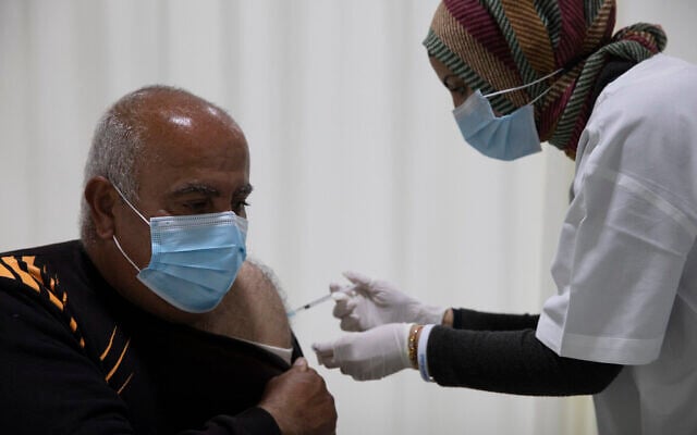 Mohamed Agbariyah  a reçu un vaccin contre le coronavirus dans un centre de vaccination COVID-19 dans la ville arabe israélienne du nord d'Umm el-Fahm, le 5 janvier 2021. (Crédit : AP Photo/Ariel Schalit)